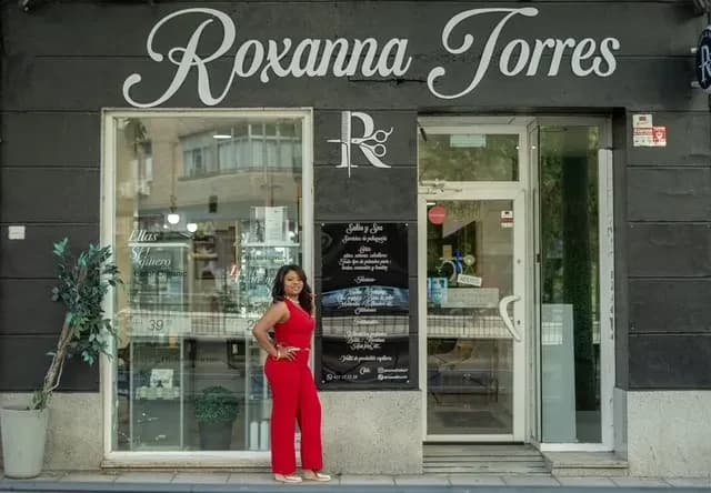 Fachada del salón Roxanna Torres en la calle Francisco Silvela, 18, con Roxanna en la puerta